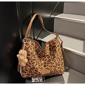 Close-up of leopard print tote bag with plush bear charm and MULAIDI brand tag