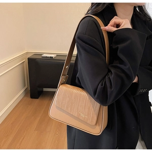 Detail of light brown shoulder bag with smooth leather and woven texture flap