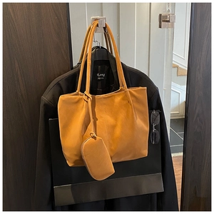 Close-up of caramel leather tote bag with matching small coin purse for women