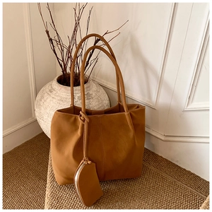 Detail of caramel faux leather tote bag set showing matte texture and stitching accents
