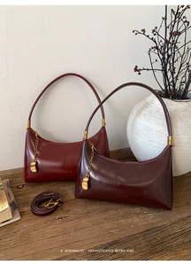 Detail showing vintage burgundy leather bags with gold chain and metal bean pendants