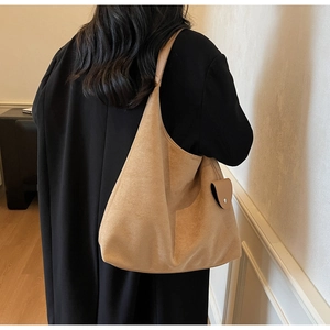 Detailed back view of a large camel suede tote bag worn on shoulder for college style