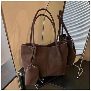 Detailed view of deep brown matte leather tote bag with matching coin purse accessory