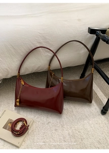 Detail view of vintage minimalist baguette bags in burgundy and dark brown shiny leather