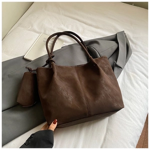 Detail of deep brown tote bag featuring white contrast stitching and mini side pouch