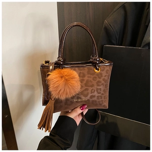 Détail d'un sac seau à motif léopard marron avec pompon en fausse fourrure et pampille
