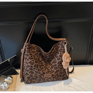 Leopard print tote bag with brown shoulder straps and a cute plush bear charm detail