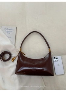 Detailed top view of retro dark brown crescent bag with dual straps and golden charm