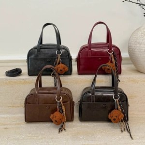 Retro vintage Boston tote bags in four colors with cute teddy bear pendants on marble stand