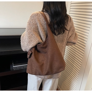 Detail of a large coffee brown suede hobo bag showing texture and slouchy drape