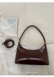 Detail of dark brown glossy leather underarm bag with a detachable shoulder strap