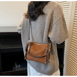 Detailed back view of a brown suede crossbody bag with elegant diamond quilting