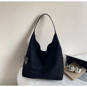 Minimalist black matte suede tote bag shown with books in a campus study setting
