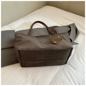 Detail of vintage brown leather tote bag with sleek handles on a minimalist background
