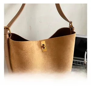 Macro detail of brown suede bucket bag featuring a premium gold twist lock closure
