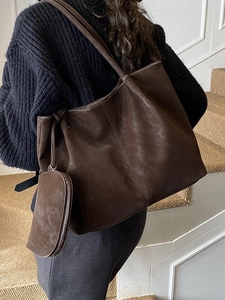 Brown leather tote bag with white contrast stitching and a matching pouch for women