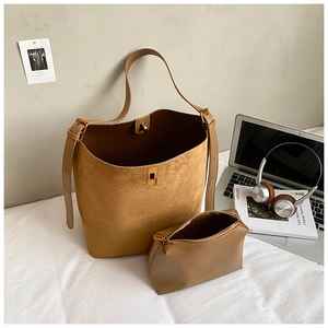 Macro shot of brown suede bucket bag texture with metallic buckle and inner pouch set