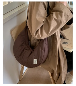 Dettaglio della borsa a mezzaluna in nylon trapuntato marrone caffè con tracolla