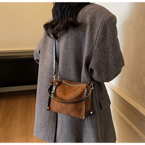 Detailed view of quilted stitching and gold hardware on retro brown square crossbody bag