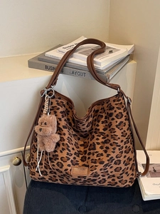 Fashionable leopard print tote bag with brown straps and cute plush dog charm