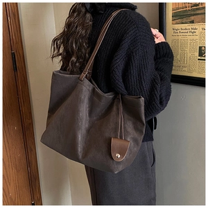 Detail of a vintage large-capacity tote bag in dark brown with textured matte finish