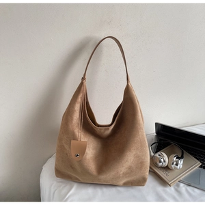 Brown suede tote bag shown with a laptop and headphones in a minimalist desk setting