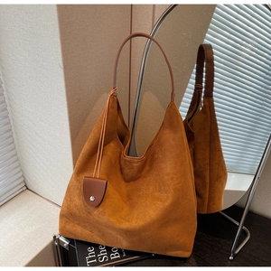 Detailed mirror view of a large brown suede tote bag with wide leather shoulder straps