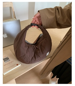 Dettaglio della borsa a mezzaluna in nylon trapuntato marrone con doppia zip