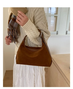 Close-up of a vintage dark brown suede hobo bag with leather strap and zipper detail