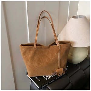 Close-up of caramel brown suede tote bag with leather glasses case accessory detail