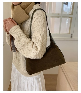 Detail of olive suede hobo bag with adjustable leather strap and side metal buckle