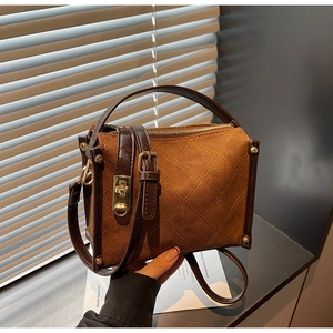 Detail of vintage brown suede crossbody bag with yellow diamond quilting and gold hardware