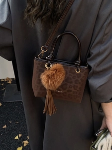 Sac seau léopard marron avec pompon et pompon sur un manteau gris élégant