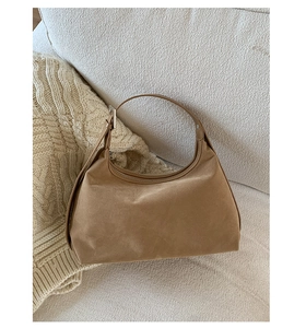 Detail view of a brown suede hobo bag with adjustable strap and minimalist vintage style