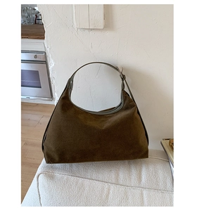 Detail of vintage matte suede hobo bag featuring adjustable leather strap and metal zipper