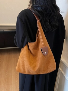 Large orange suede tote bag with brown straps and metal buckle charm, minimalist style