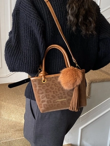 Sac seau chic à imprimé léopard avec breloque en peluche et poignée en cuir sur modèle