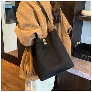 Close-up of black suede bucket bag with signature golden square metal twist lock mechanism