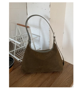 Detail of dark brown suede hobo bag with smooth zipper closure and premium texture