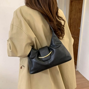 Detail of minimalist black hobo bag featuring gold metallic buckle and soft faux leather texture