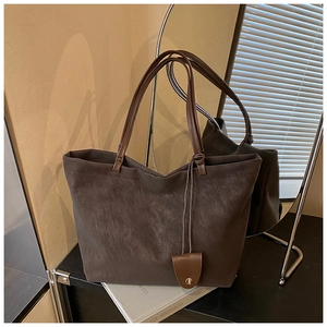 Macro shot of dark brown matte leather tote bag texture with minimalist metallic buckle detail