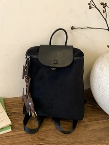 Classic black nylon backpack with leather flap and cute animal charm for travel