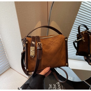Detail view of vintage brown patchwork square handbag with gold hardware and suede texture