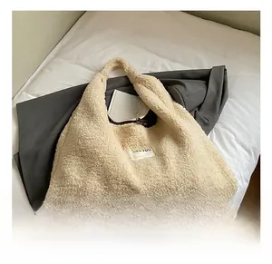 Close-up of fluffy cream lamb wool tote bag with white woven label and soft hobo texture