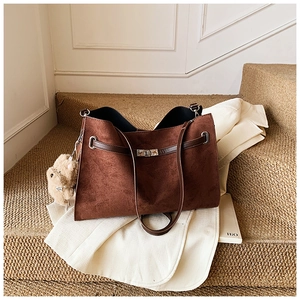 Detail of vintage large brown tote bag with silver twist lock and plush bear pendant