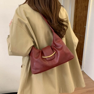 Detail of burgundy Hobo bag featuring a large golden crescent buckle and soft texture