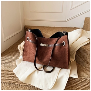 Detail of dark brown suede tote bag showing its matte texture and silver turn-lock closure