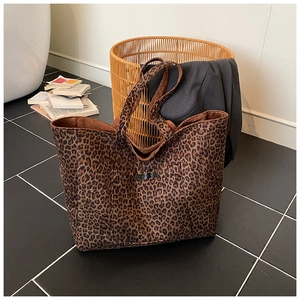 Détail du sac cabas en toile à motif léopard avec étiquette tissée dans un décor