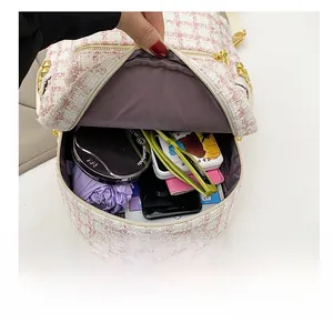 Detail view showing internal capacity of pink and white tweed backpack with gold studs