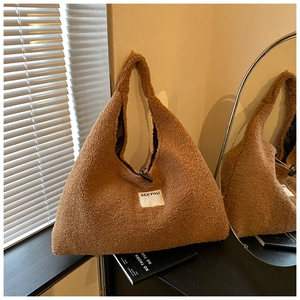 Detail of soft brown faux shearling tote bag with minimalist white fabric label